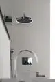 Regenbrause mit runder Kopfbrause und integrierter Beleuchtung von Ideal Standard. Montiert an einer hellen Wand, mit einer Steuerungseinheit in Chrom.